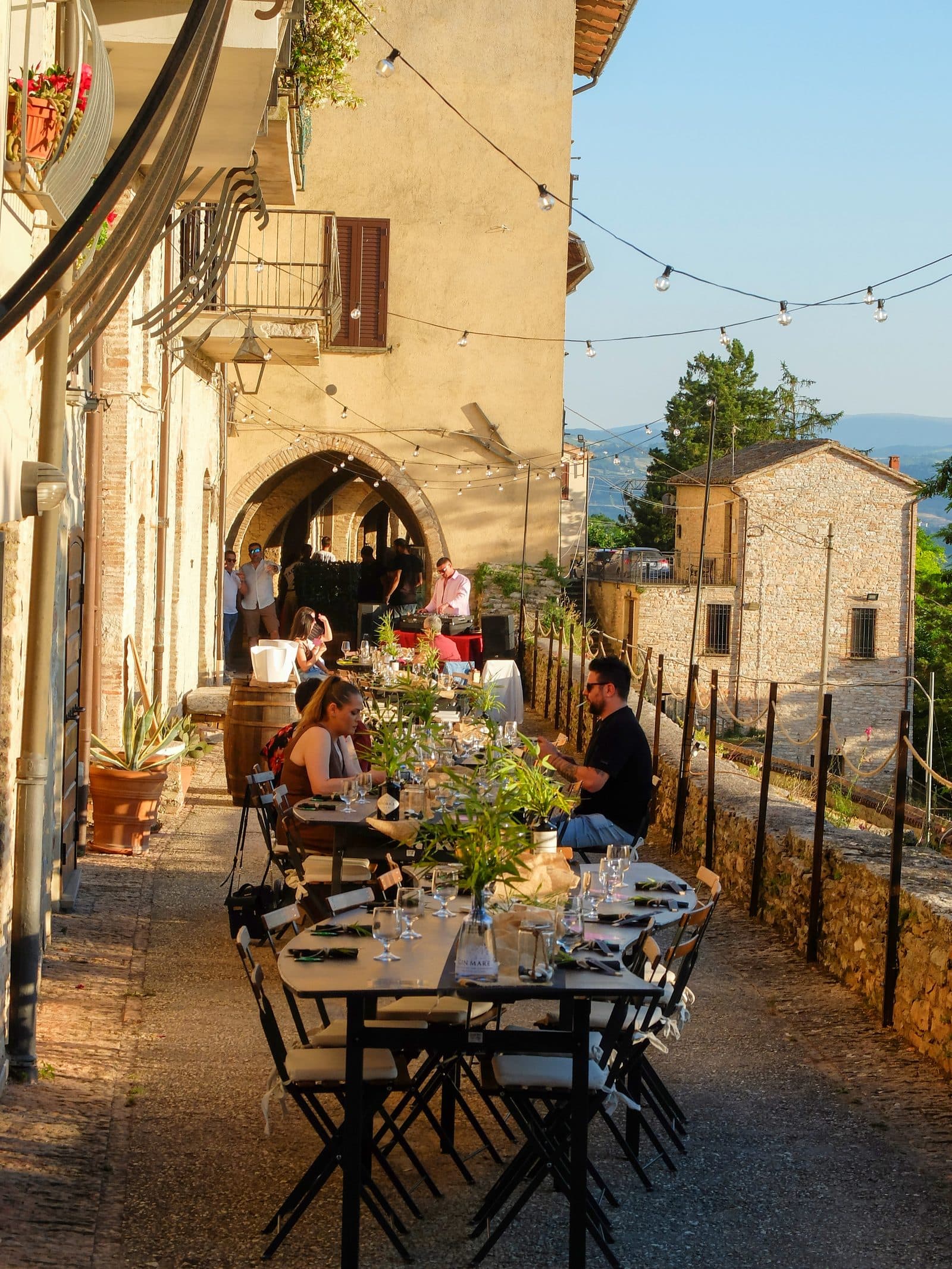 Tavoli allestiti tra archi medievali di Via Rughe